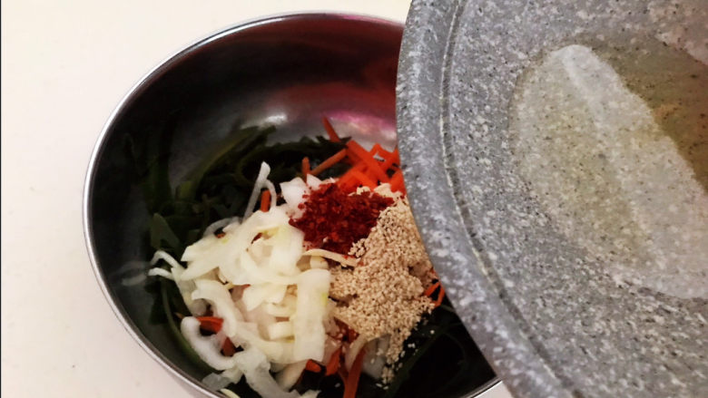 香辣海带丝,趁热把大豆色拉油倒入盆中,把大蒜和辣椒粉的香味激发出来