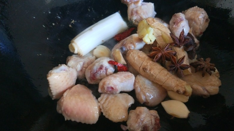 小鸡炖蘑菇粉条,倒入鸡块炒均匀,加入葱姜蒜炒香。