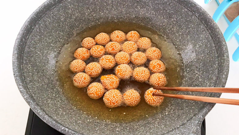 南瓜芝麻球,用筷子把每个南瓜芝麻球压一压,给南瓜芝麻球排排气