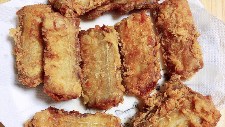 炸酥带鱼,盘中放入吸油纸,炸好的带鱼放在上面吸取多余的油。