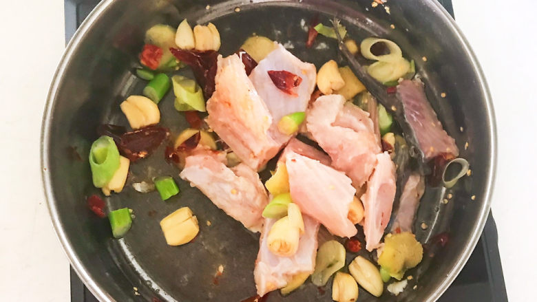 老坛酸菜鱼,加入鱼骨,翻炒1分钟