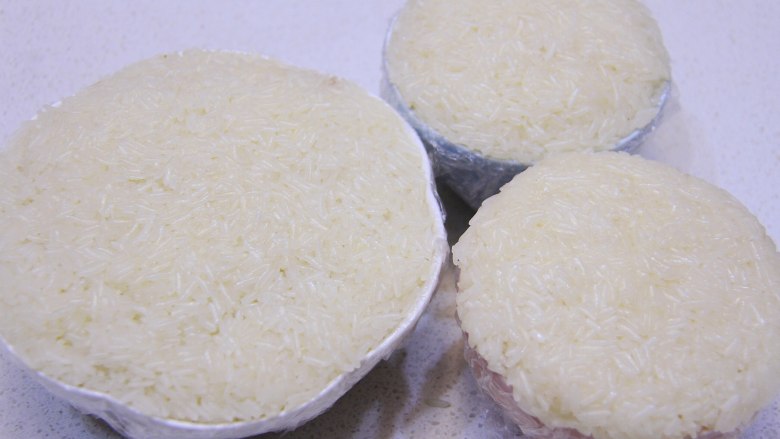 香糯可口八宝饭, 最后在表面铺一层糯米饭,完全包住豆沙馅料,按压好与碗边一样高即可。