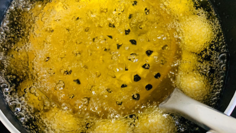 南瓜芝麻球,要轻轻按压浮起的南瓜球,抬起笊篱,这样反复操作。
