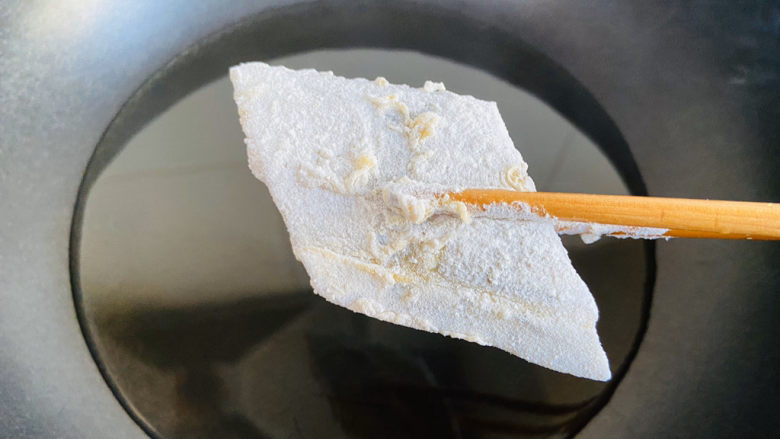炸酥带鱼,锅中倒入食用油加热至七成热,带鱼块入油锅