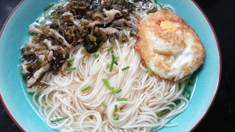 雪菜肉丝面,碗里加热水捞入面条,码上雪菜肉丝,加上一个荷包蛋