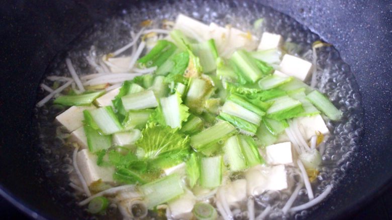 海蛎子豆腐青菜汤,大火烧开后,先放入小白菜茎煮沸。
