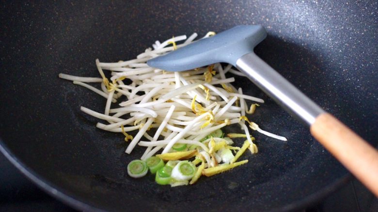 海蛎子豆腐青菜汤,另起锅倒入<a style='color:red;display:inline-block;' href='/shicai/ 849'>花生油</a>烧热后,先爆香葱姜碎,再把绿豆芽放入锅中,大火快速翻炒均匀。