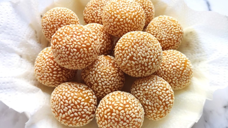 南瓜芝麻球,盘子里铺上厨房用纸,放上炸好的南瓜芝麻球,吸一吸多余的油分。