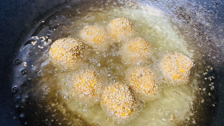 南瓜芝麻球,油锅烧到五成热时,依次放入南瓜芝麻球,小火慢炸