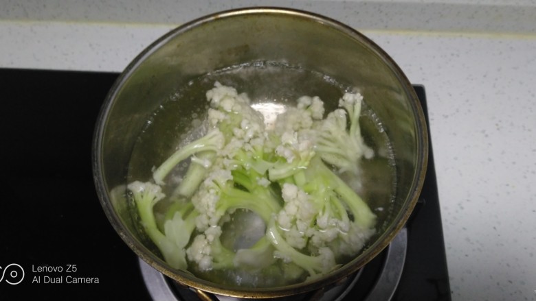 猪肉炒有机菜花、平菇,锅中放入适量清水，水开后放入菜花焯水90秒