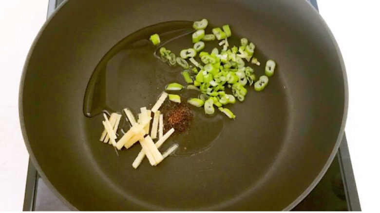 青菜炒香菇,炒锅烧热后加入大豆色拉油,油烧热后加入姜丝和葱花