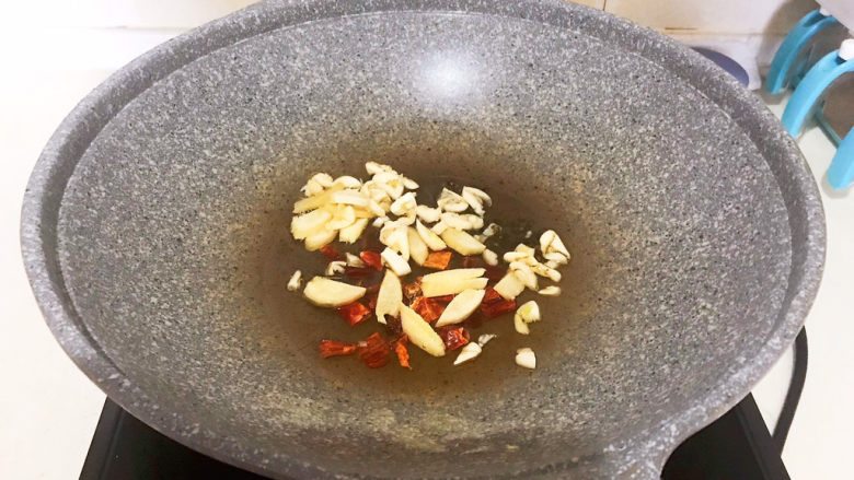 酱焖黄花鱼,炒锅烧热后加入大豆色拉油,油烧热后加入花椒粒和干红辣椒段,炒出香味,再加入葱姜,煸炒出香味