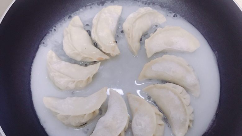 香菇虾仁饺子,倒入锅中加盖。先用中火,煮至水差不多干时改用小火,直至饺子能轻易晃动即可。
