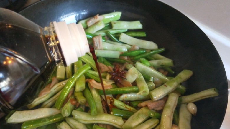 五花肉炖豆角,倒入自然鲜酱油。