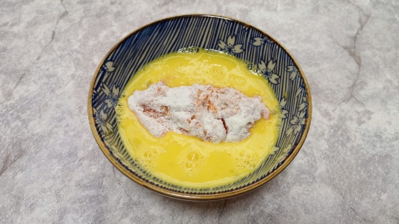 香酥炸鸡翅,然后放入鸡蛋液里面浸泡几秒钟,沾满蛋液。