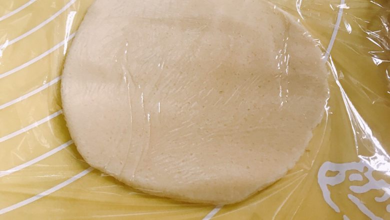 菠萝面包,取出一小份酥皮,用保鲜膜盖住,用擀面杖擀成圆形