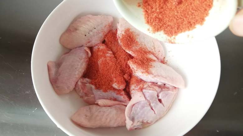 香酥炸鸡翅,放入容器里,撒上奥尔良烤肉料。