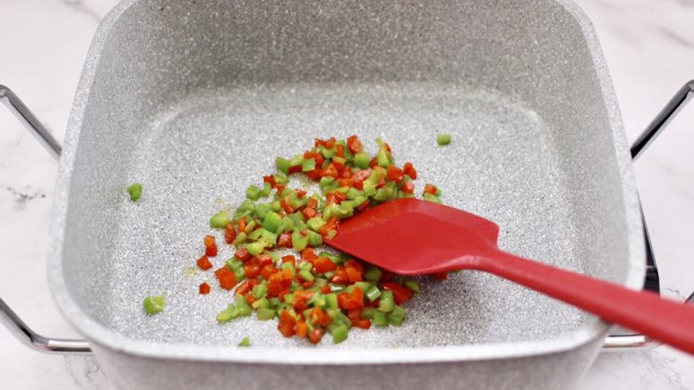 蒜香粉丝双椒青口贝,锅中倒入剩下的5克花生油烧热后,把青红椒碎翻炒至变色断生后,盛出备用。