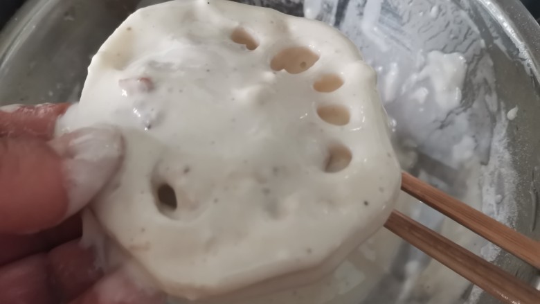 藕夹肉,把多余的面糊刮掉。面糊调制的状态就是能刚刚让藕挂住就好,太厚了炸出来也不好吃。