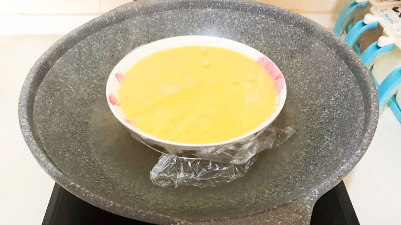 南瓜鸡蛋羹,锅里水开后把装有鸡蛋液的汤盘放在蒸屉上面