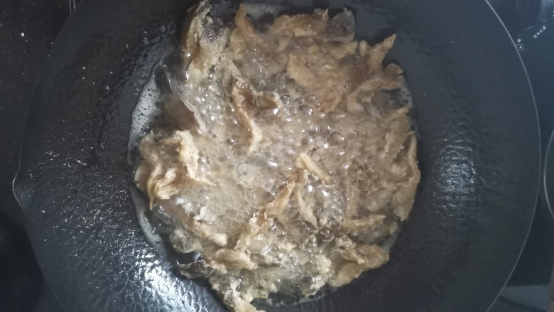 孜然蘑菇,锅里大火热油,炸好的蘑菇再复炸一下,大约十秒就捞出沥油