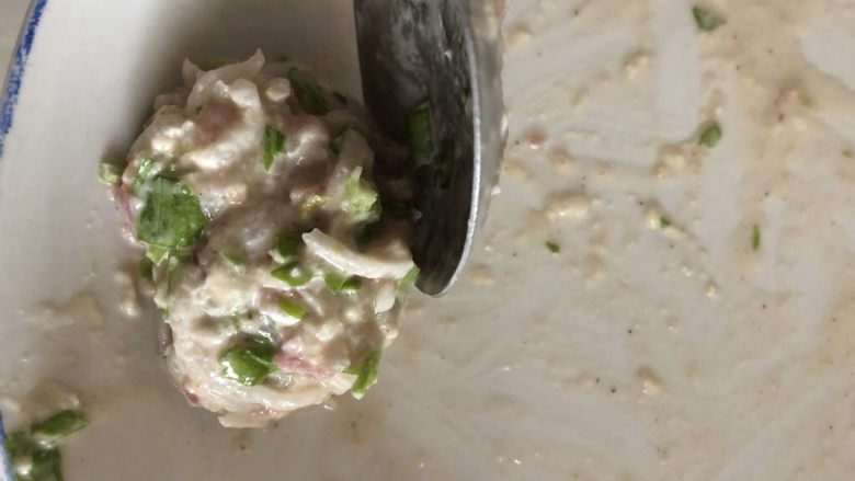 炸萝卜丝丸子,用勺子辅助,把糊糊团成圆形。
