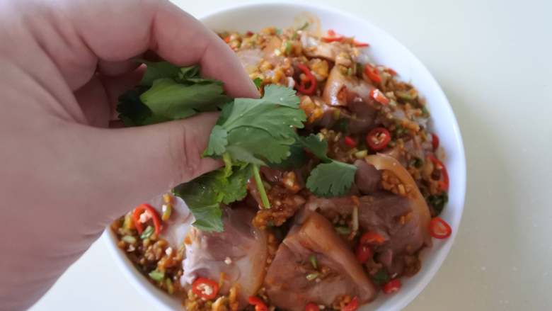 温拌肘花,撒上小米椒,放上香菜叶即可