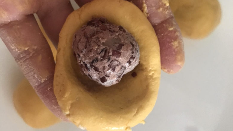 脆皮南瓜饼,取一小块南瓜糯米面团压扁,包入豆沙