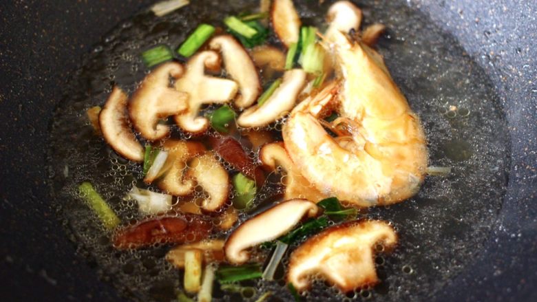 鲍鱼对虾香菇菠菜面,大火翻炒均匀后,倒入煮鲍鱼的汤汁和对虾。