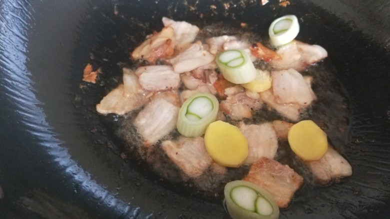 紫甘蓝炒饼丝,锅中倒入适量油炒五花肉,放入葱姜蒜一起炒干一点。