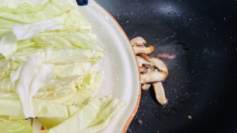 鸡蛋炒年糕,锅中留底油入香菇和卷心菜