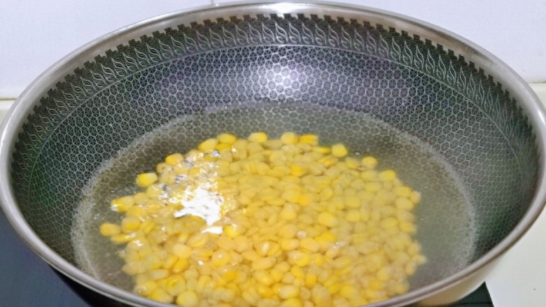 蛋黄焗玉米,玉米粒焯水,锅中加入水,玉米粒冷水下锅,大火烧开,转中火煮熟。