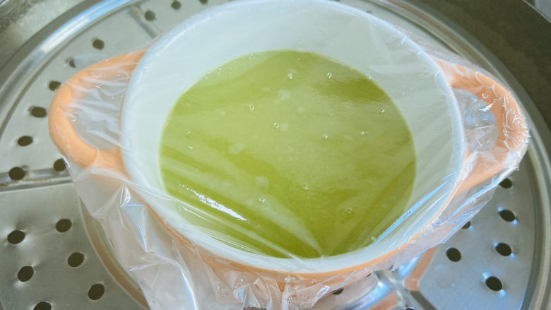 菠菜鸡蛋羹,盖上保鲜膜,用牙签扎几个洞。大火烧开转中火蒸八分钟后再焖两分钟