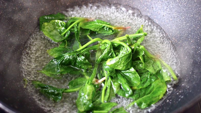 菠菜鸡蛋羹,锅中倒入适量的清水,加少许盐和几滴食用油烧开,把洗净的菠菜进行焯水,断生变色即可关火。