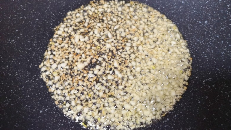 粉丝蒸金针菇,炒锅内倒适量的食用油烧热,下入蒜末小火炒至金黄色。