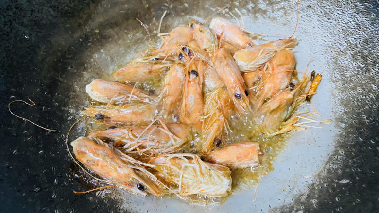 蔬菜虾仁粥,煮粥的时候令起一个锅炸虾油:锅中倒入食用油加热至七成热放入姜丝爆香再放入虾头小火慢炸,炸至出油即可