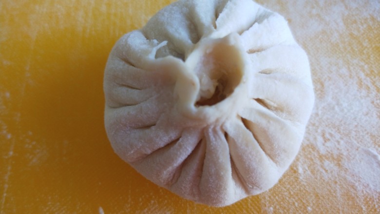 猪肉白菜包子,包成包子,一半封口,一半捏紧。
