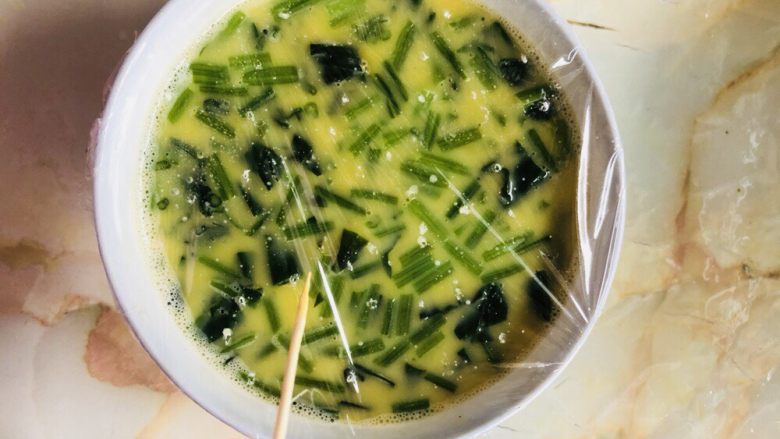 菠菜鸡蛋羹(两个版本),封上保鲜膜,用牙签扎几个小孔。这碗适合稍大年龄且不爱吃菜的孩子,切段保留了菠菜的营养物质。
