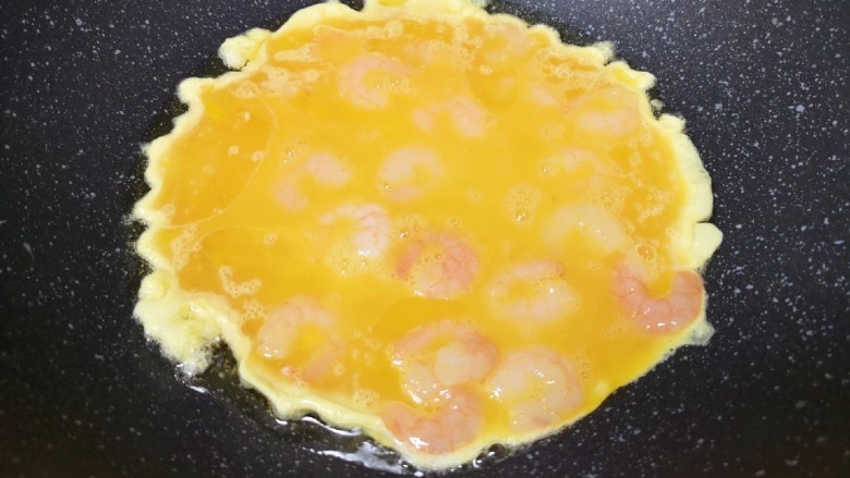 虾仁跑蛋,炒锅内倒适量的食用油烧热,倒入虾仁蛋液。