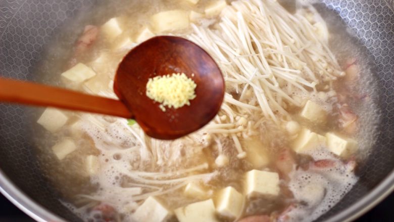 金针菇豆腐鱿鱼煲,继续大火煮1分钟左右,放入<a style='color:red;display:inline-block;' href='/shicai/ 756'>鸡精</a>增加口感。