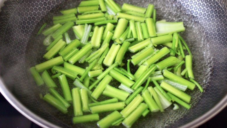 香辣八爪鱼,锅中倒入适量的清水烧开,加入少许盐和几滴食用油,把芹菜进行焯水,变色即可捞出。