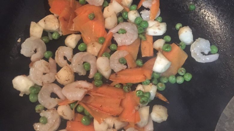 五彩荸荠虾仁,加入虾仁🍤和荸荠一起翻炒,这两个顺序可以互换一下也没事了,注意胡萝卜要烧熟一点,加入少许盐和清水翻炒至虾仁微微变色