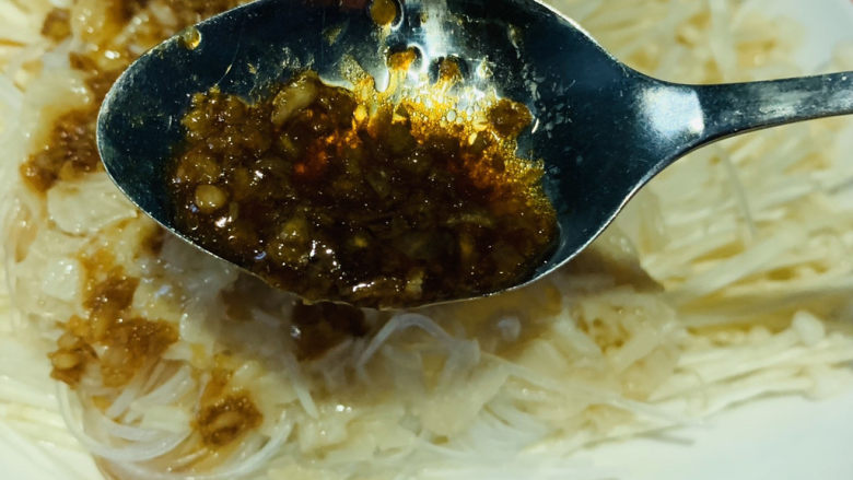 粉丝蒸金针菇,将蒜蓉加到准备好的粉丝金针菇表面;