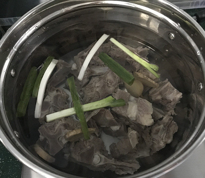 羊骨头汤,将葱段、姜片和羊骨头一同放入汤锅中,加入适量清水