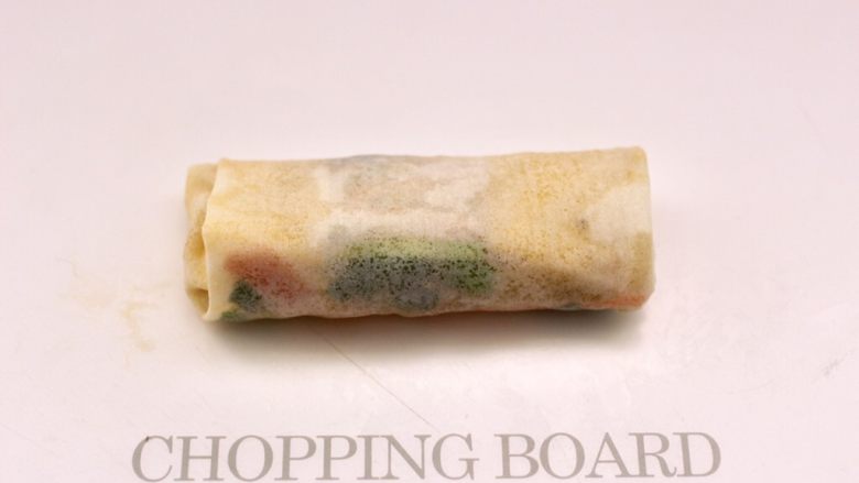 合菜春卷,先卷一下,再把两边往中间折,全部卷起来就可以了。