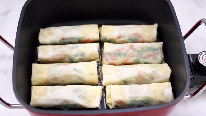 合菜春卷,平底锅烧热,倒入花生油烧热,放入做好的春卷。
