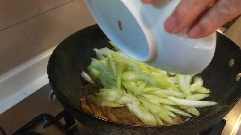 芹菜炒牛肉,加入酱油炒均匀倒入芹菜。