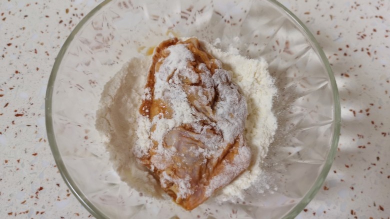 薯片鸡翅,腌制好的鸡翅从冰箱里取出,先放入面粉里面,表面粘上一层面粉。