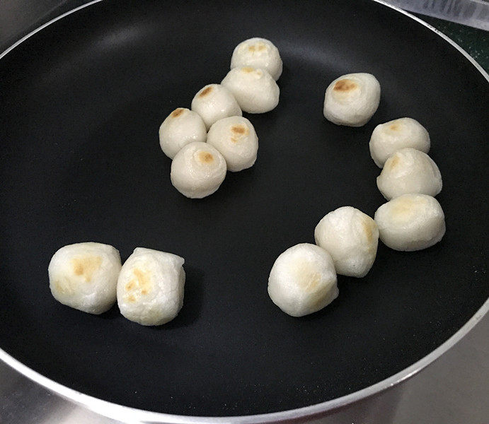 炒元宵,炒着炒着,元宵会慢慢地变大,表面起一层微焦皮就不容易蘸黏了