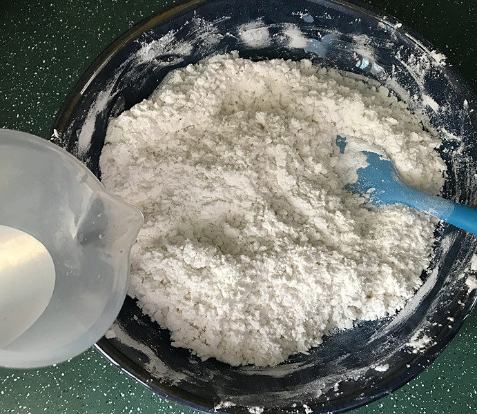 炒元宵,再少量多次加入室温水,边加边搅拌,70克不一定全加完,能成团即可